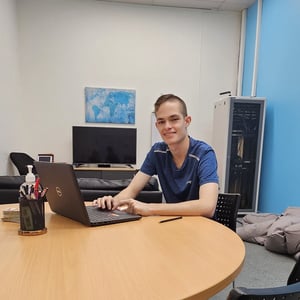 a person sitting at a table with a laptop