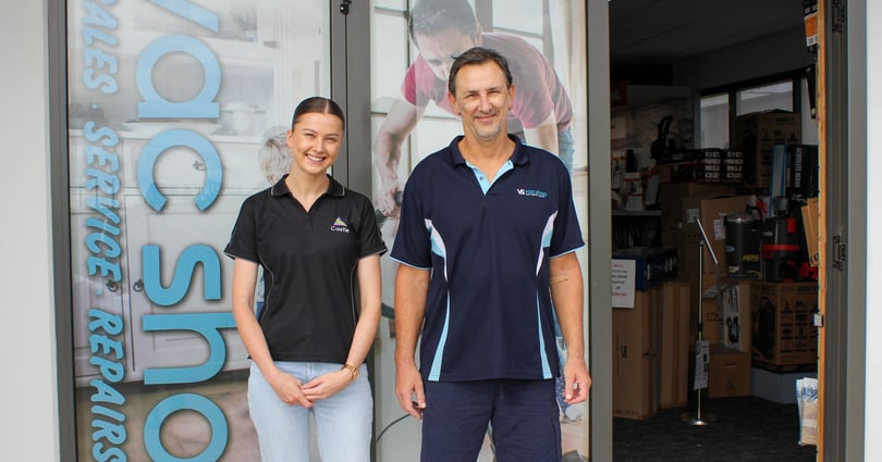 Amy and Ben posing in front of the Vac Shop workshop entrance.